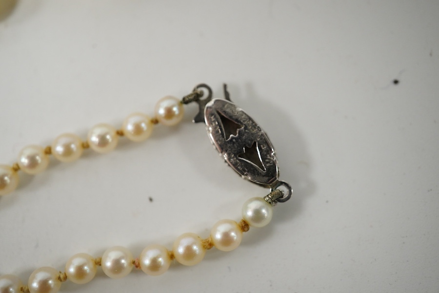 A double strand graduated culture pearl necklace, with marcasite set sterling clasp, 46cm and one other single strand cultured pearl necklace. Condition - fair